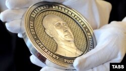 Russia – A commemorative silver coin bearing a portrait of Vladimir Putin to mark the Kremlin's takeover of Crimea, Chelyabinsk, April 23, 2014