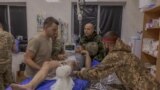 TOPSHOT - A Ukrainian wounded serviceman who was brought back from positions is being treated by Ukrainian military doctors is prepared to be transported to a hospital, at a stabilisation point of the 33rd Mechanised Brigade, near the Kurakhove town's fro